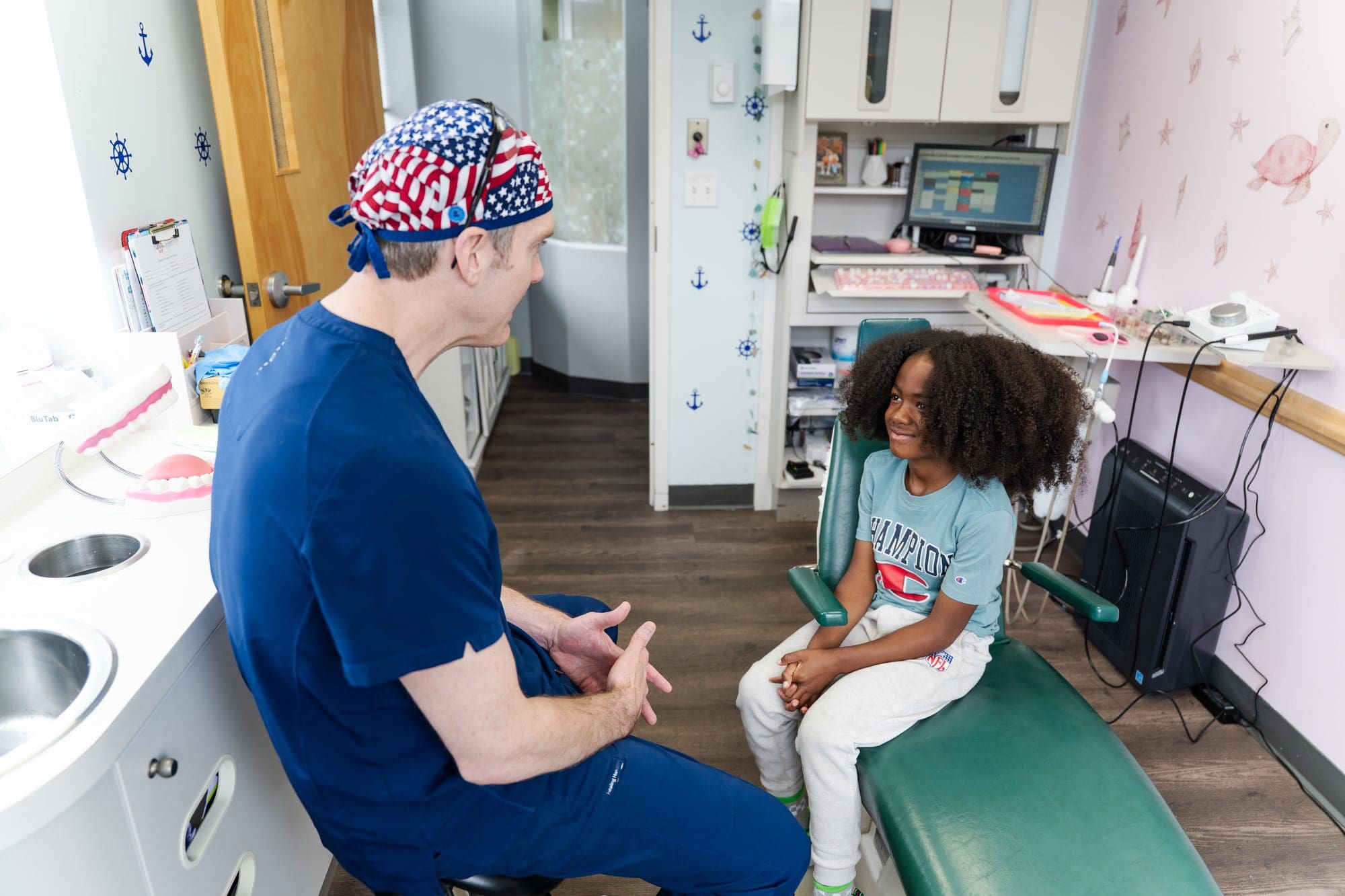Dentist consulting child patient at Falmouth Pediatric Dentistry in Falmouth, ME