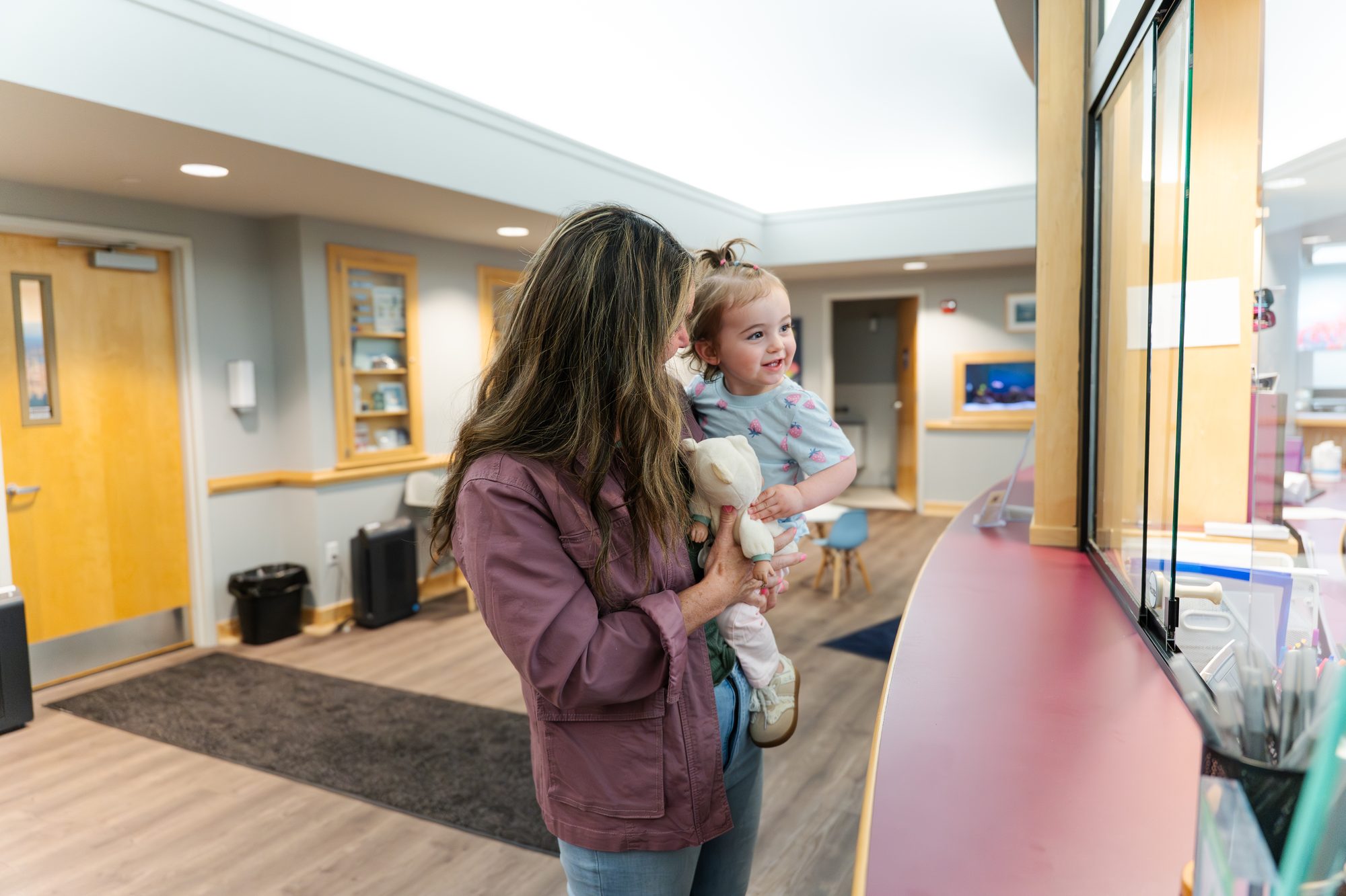 Mother holding child at Falmouth Pediatric Dentistry reception in Falmouth, ME